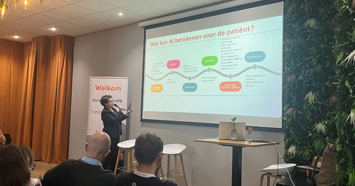 Foto van een presentatie tijdens het 'innovatiecafe in de zorg'. Titel van de slide in beeld is 'Wat kan AI betekenen voor de patiënt?'