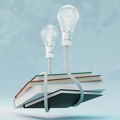 Surreal visual of a floating pile of books wrapped in the cords of 2 lightbulbs