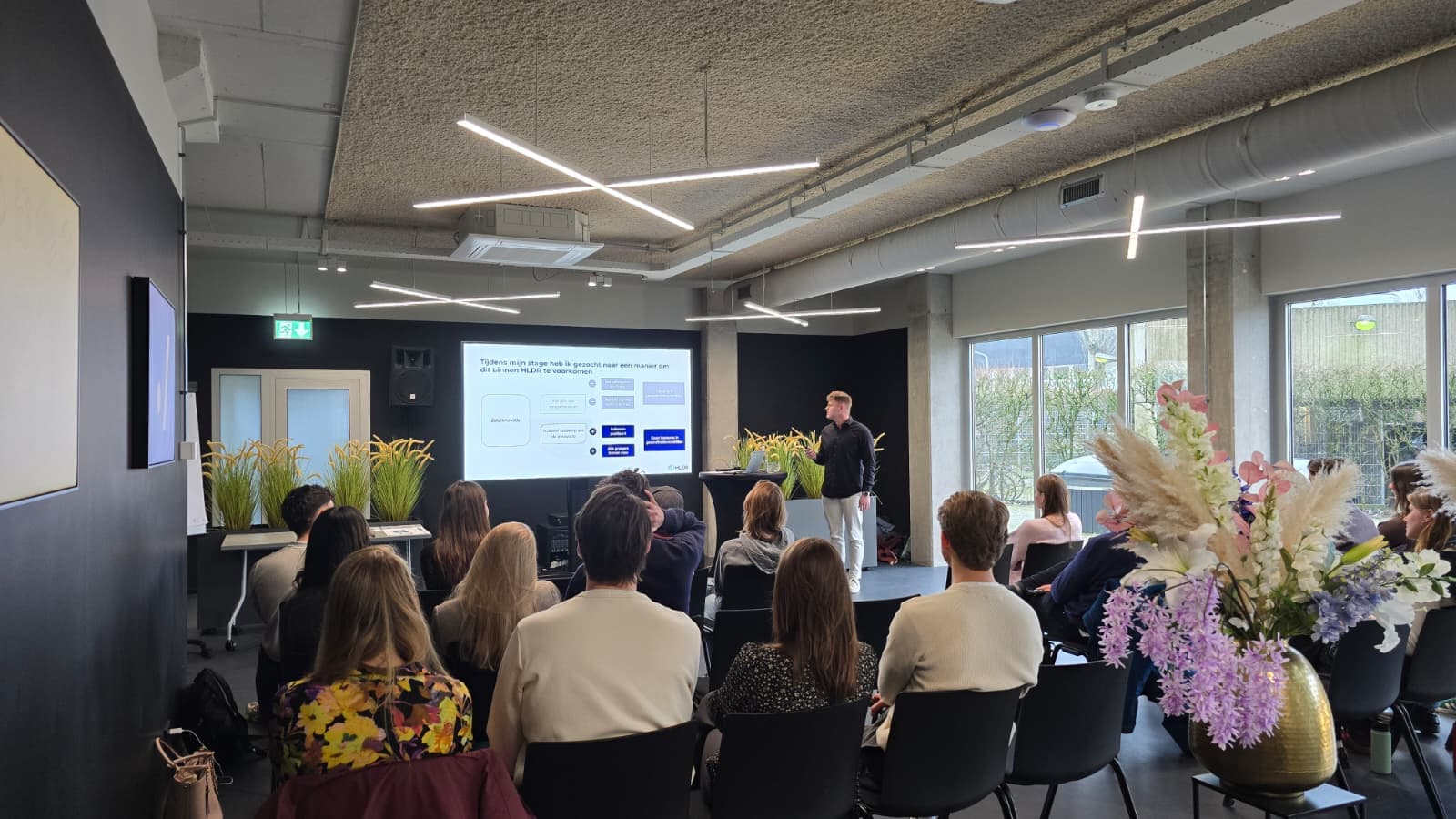 Foto van Thijs die zijn eindpresentatie van z'n stage geeft.